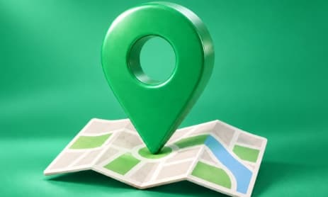 A green map pin standing on a folded street map